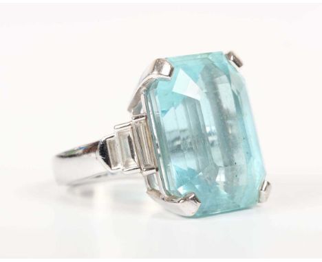 A white gold, aquamarine and diamond ring, claw set with a cut cornered rectangular step cut aquamarine between baguette cut 