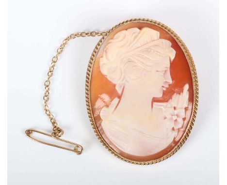 A 9ct gold mounted oval shell cameo brooch, carved as a portrait of a lady with a spray of flowers, Birmingham 1977, weight 1