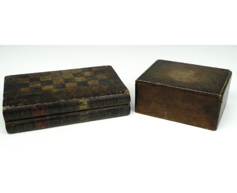 A turned boxwood chess set in an oak cigar box, and a backgammon board formed as two calfskin bound books, with chess/draught