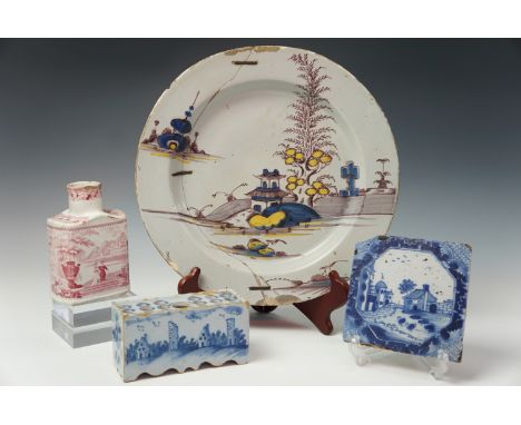 An 18th century Delft flower brick, raised on serpentine feet, a Delftware (riveted) charger with Oriental influenced decorat