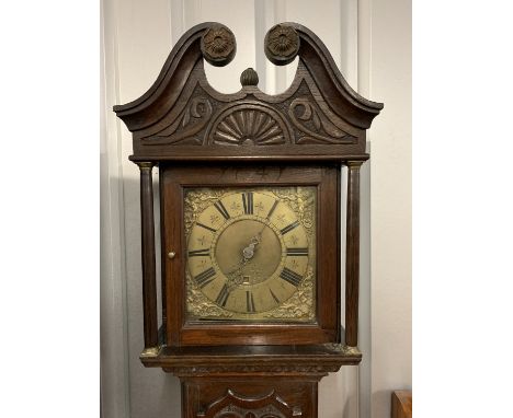 An 18th Century brass-faced long case clock in a later-carved oak case, 197 cm
