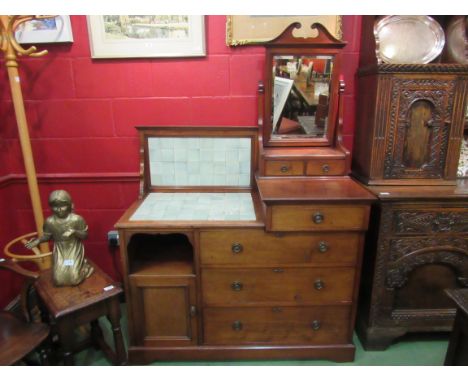 In the manner of "Maple &amp; Co" a late Victorian walnut combination washstand dressing chest, the tilt mirror over six draw