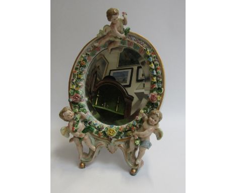 A ceramic free-standing mirror with cherub detail