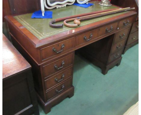 A Georgian style mahogany twin pedestal writing desk the tooled leather writing surface over nine drawers on bracket feet, 12