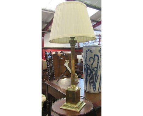 A brass column form lamp with shade