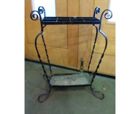 A wrought metal black painted stick stand with scroll detail and drip tray, 68cm tall x 51cm wide x 34cm deep