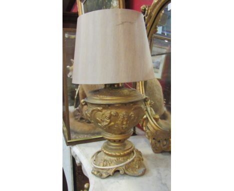 An ormolu table lamp base with classical putti design, cream shade