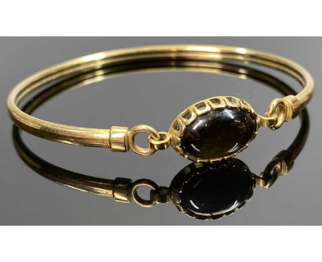 9CT GOLD BANGLE - having an oval cabochon black stone, 5.7grms