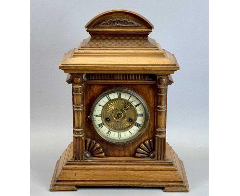GERMAN WALNUT CASED MANTEL CLOCK - the arched top with carved fish scale decoration, circular dial having cream chapter ring 