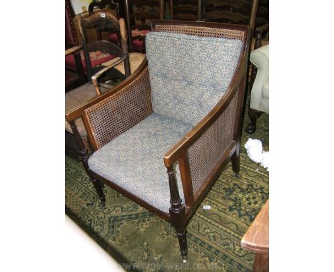 A 19th c. Mahogany framed Easy Chair having square back, forward swept arms on tapering reeded turned supports, with cane sea