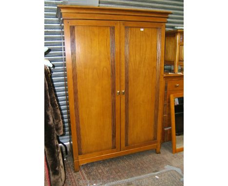 A good quality modern Maple two door Wardrobe with moulded cornice over the pair of opposing full length single panel doors w