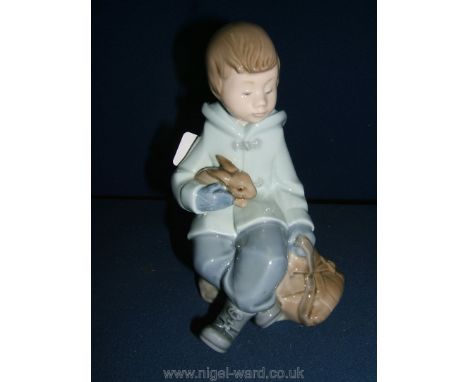 A Nao figurine of a boy with rabbit