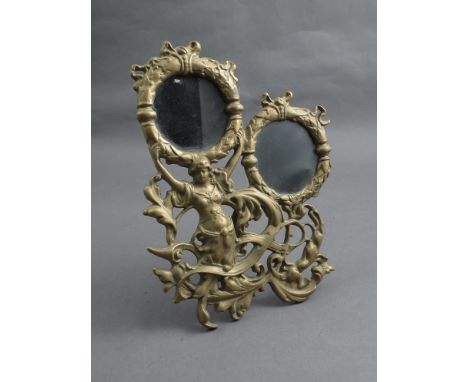 A brass double photograph frame, maiden in foliate scrolls, easel back 