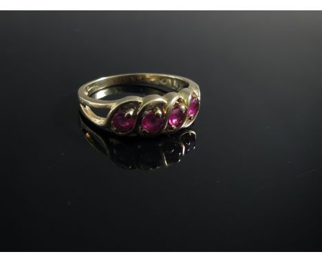 A 9ct gold four stone ring set with rubies with swirled setting 