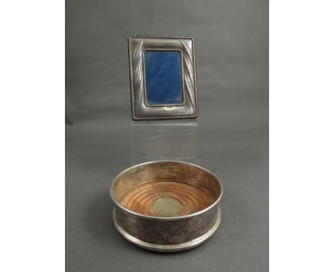 A plated bottle coaster and a Continential silver metal easel back photograph frame 