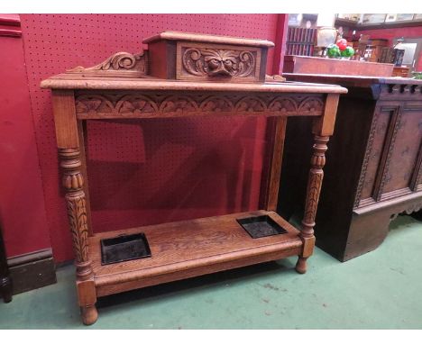 A Victorian carved oak stick stand with central glove drawer, drip trays 