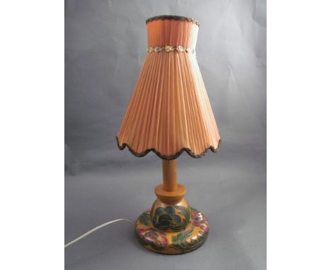 A mid 20th Century table lamp with painted flowers, edged with a metal trim, peach chiffon pleated shade with scalloped edge 