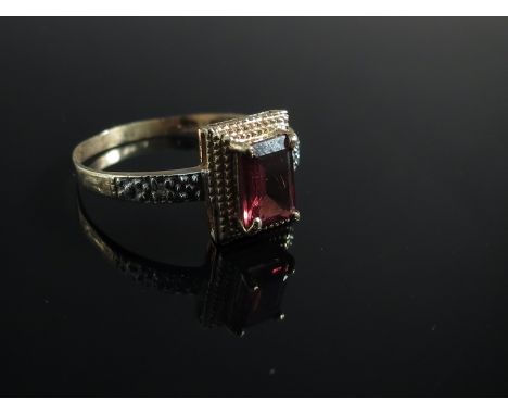 A yellow metal ring set with emerald cut citrine flanked by chip diamond shoulders, stamped 10k