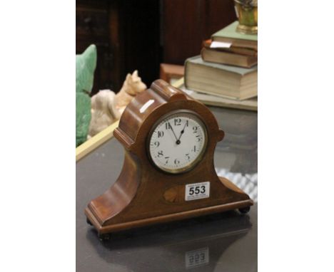 An Edwardian inlaid mantle clock raised on ball feet.