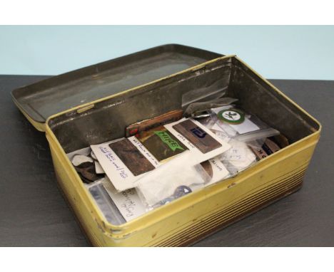 Tin containing badges, fobs, stick pins, etc