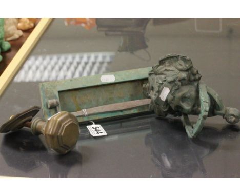 A brass door knocker of classical form a door knob and letter box.