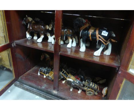 A quantity of ceramic  shire horses and  carts.