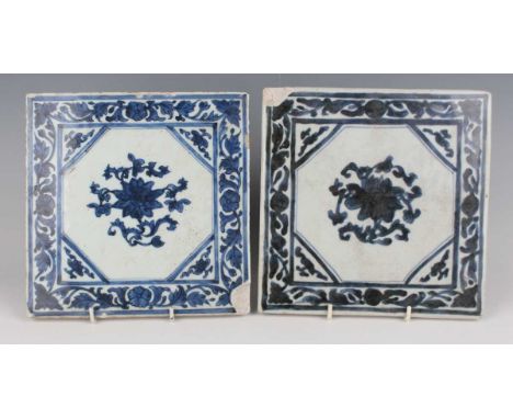 Two Chinese blue and white export porcelain square tiles, Kangxi period, each painted with lotus within scrolling tendril bor