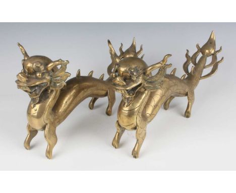 A pair of Chinese brass figures of dragons, early 20th century, each modelled standing with scale decoration, length 34.5cm.