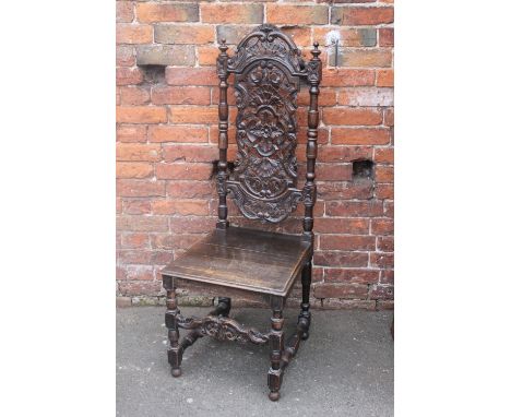 A JACOBEAN STYLE OAK DINING CHAIR, having a typical carved back, plank seat