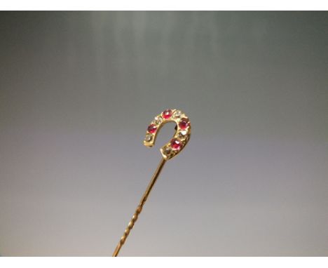 A YELLOW METAL DIAMOND AND RUBY SET HORSESHOE STICK PIN, the horseshoe set with five old cut diamonds - combined weight 0.23 