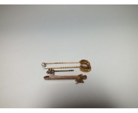 A 9CT GOLD FOX HEAD STOCK PIN / BROOCH, together with three yellow metal stick pins, to include a gem set butterfly example a