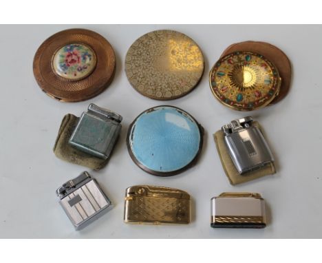A SILVER AND ENAMEL POWDER COMPACT  A/F, along with three powder compacts and a quantity of lighters