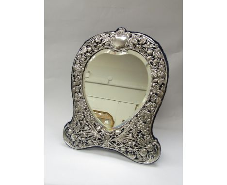 A Victorian Goldsmiths &amp; Silversmiths Co. silver easel back table-top mirror of heart form, ornate pierced design of leav