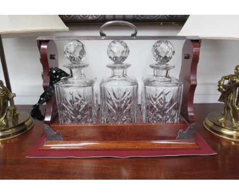 A 20th Century mahogany lockable three bottle tantalus with Royal Doulton crystal decanters 39.5cm long 