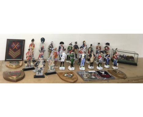 A collection of ceramic soldier figures, plus cloth badges and wall plaques