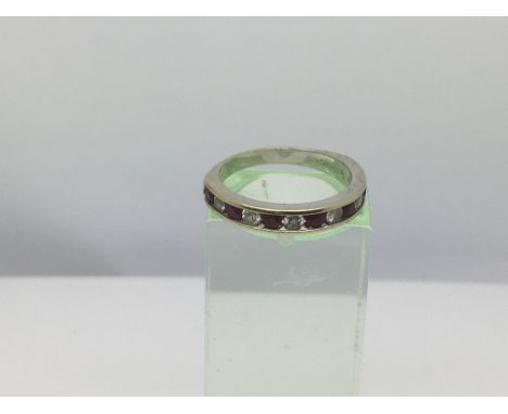 An 18ct white gold ring set with alternating rubies and diamonds, approx 2.8g and approx size K.