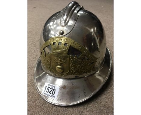 A vintage French firemans helmet with brass badge inscribed Saprurs, Pompiers, De ales Pins silver plated.