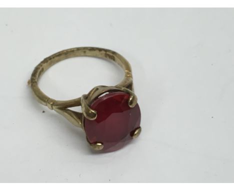 A 9ct gold ring set with a red stone.Approx 3.8g, L/M