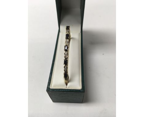 A unmarked bangle inset with gem stones.