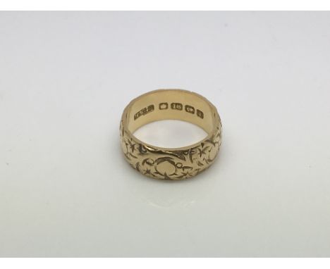 An 18ct gold wedding band with engraved decoration, approx 6.7g and approx size K-L.