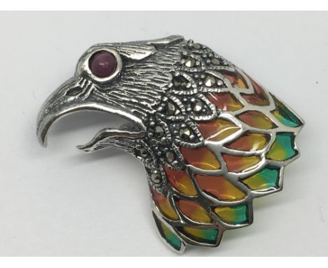 A silver eagle head brooch set with ruby eye, coloured enamel and marcasite