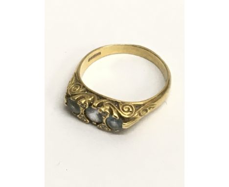 A 22ct gold ring set with three pale blue stones.Approx R, 5.4g