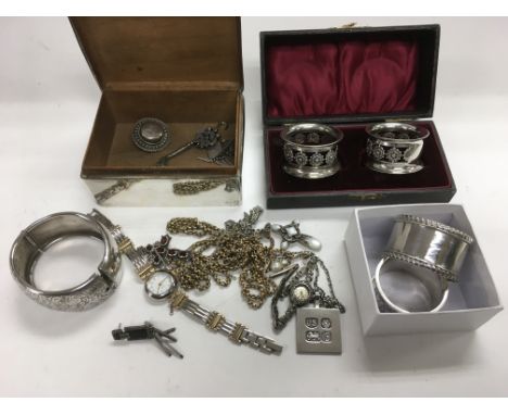 A collection of mainly silver items including a cigarette box, bangle, napkin rings and jewellery.