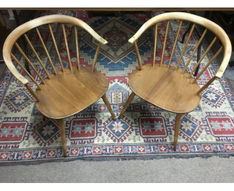 A pair of Ercol light wood , curved back chairs.Some wear
