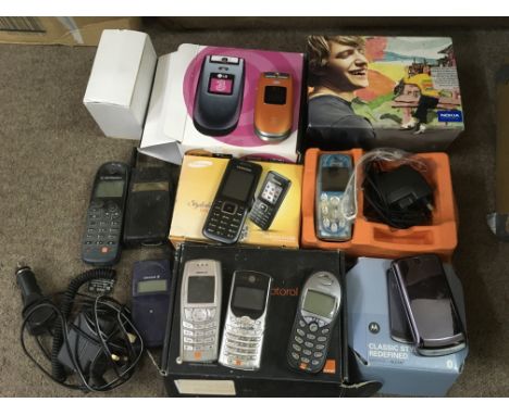 A box of vintage mobile phones, mostly in original boxes.