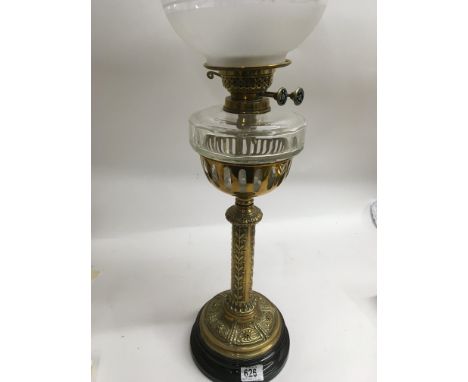A Victorian brass oil lamp with gothic influence with shade a chimney.