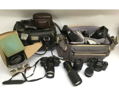 A collection of cameras including a Nikon SLR, lenses plus a Silva Marine Compass