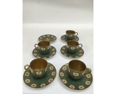 A set of five Royal Worcester, green ground coffee cups and saucers painted with flowers and gilded highlights