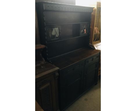 A dark oak dresser with glass panel doors to front.Approx 47x127x187cm high