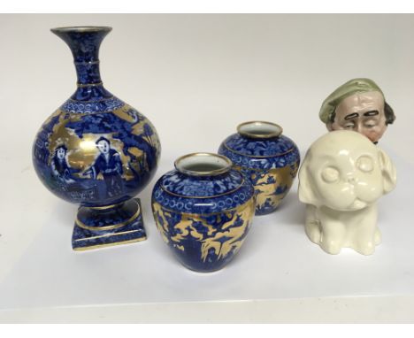 Three Early 20th century blue and white and gilt vases and a Crown Devon dog and a ceramic figure.